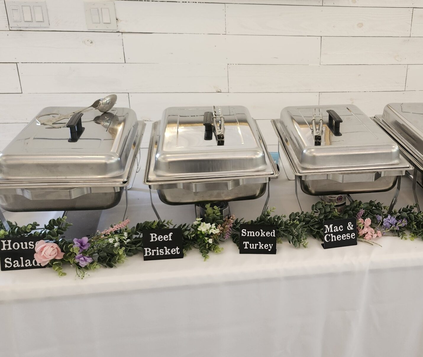 Wedding food table catering with decor and labels of what each tin is